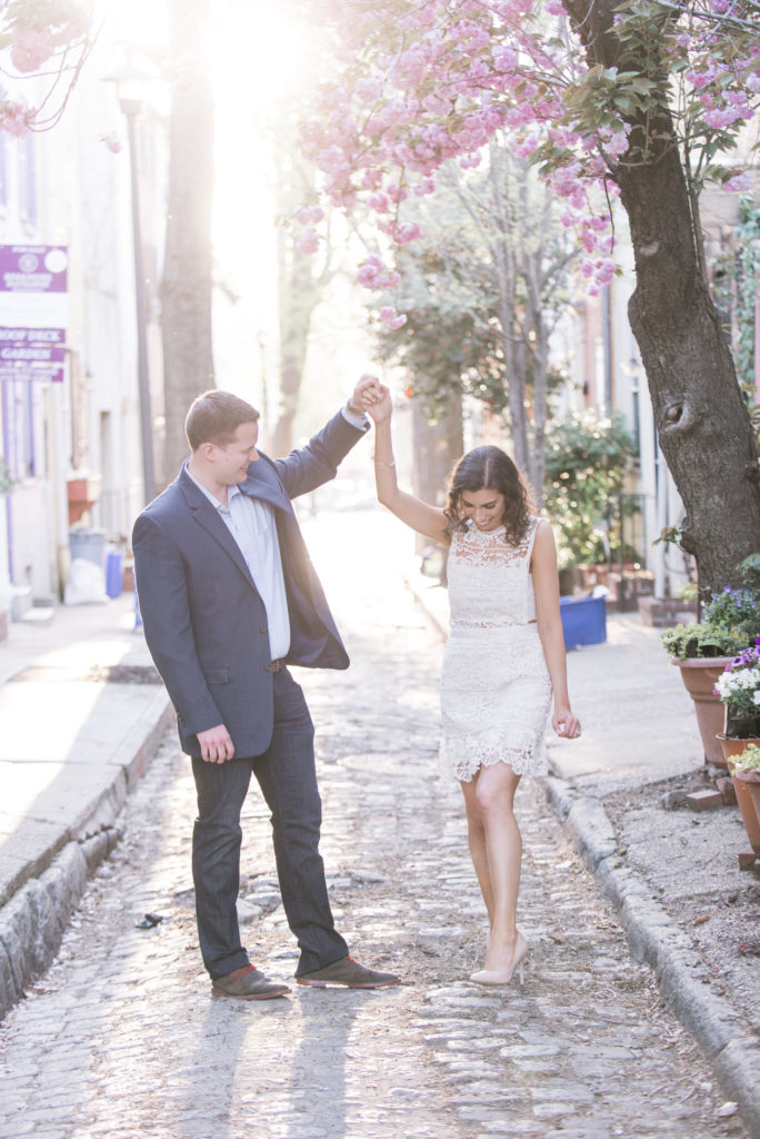 A couple standing in the middle of a cobblestone street modeling what to wear to your engagement session