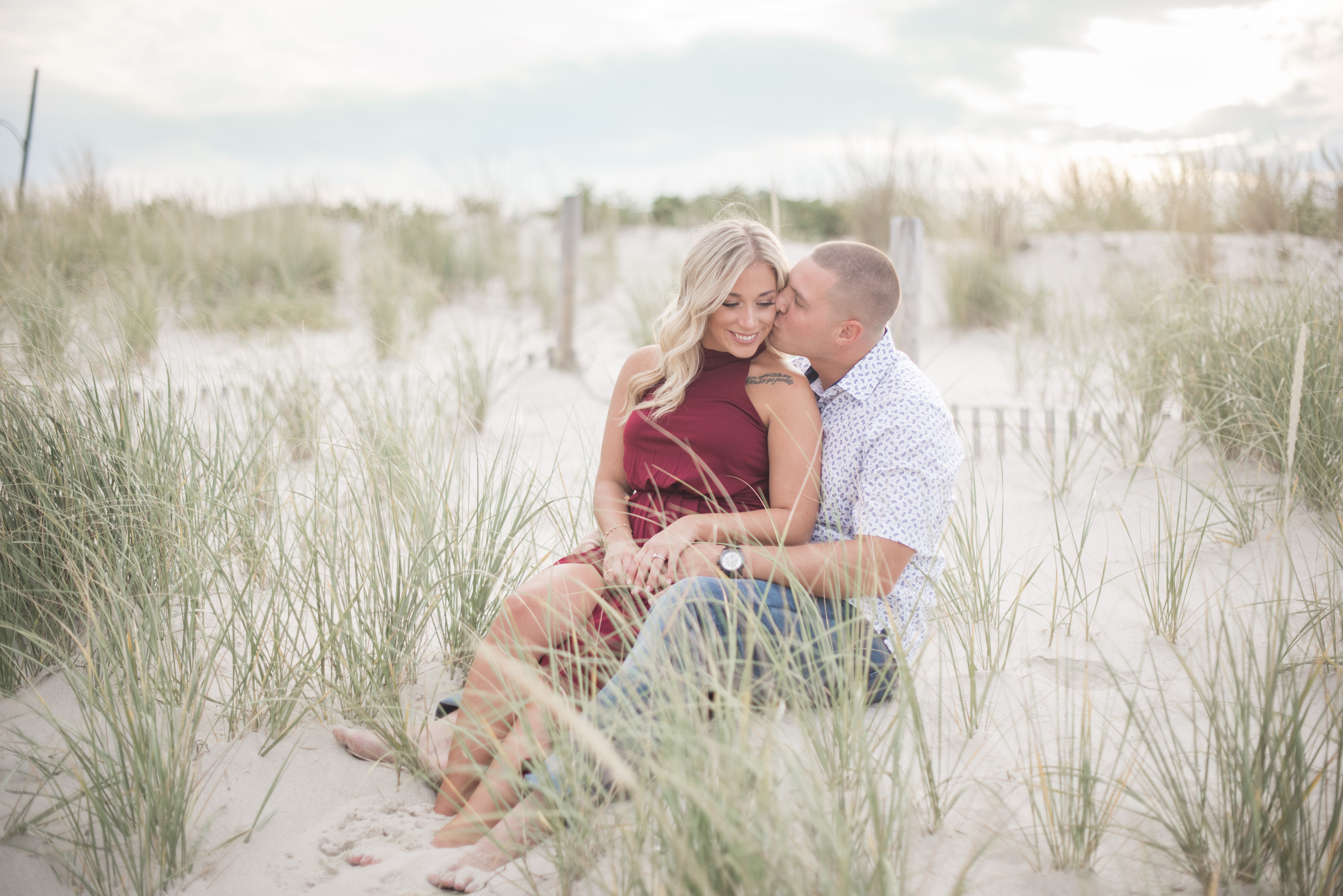 couple sitting on the beach modeling what to wear to your engagement session