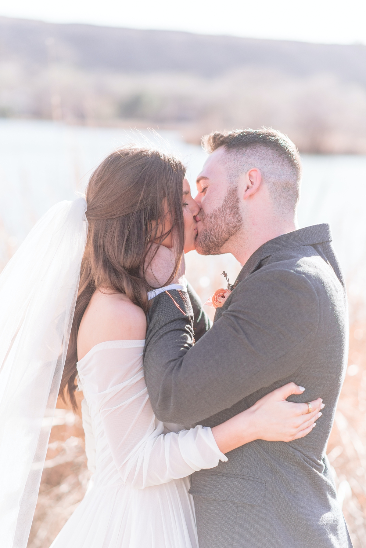 a bride and groom kissing in direct sun light image