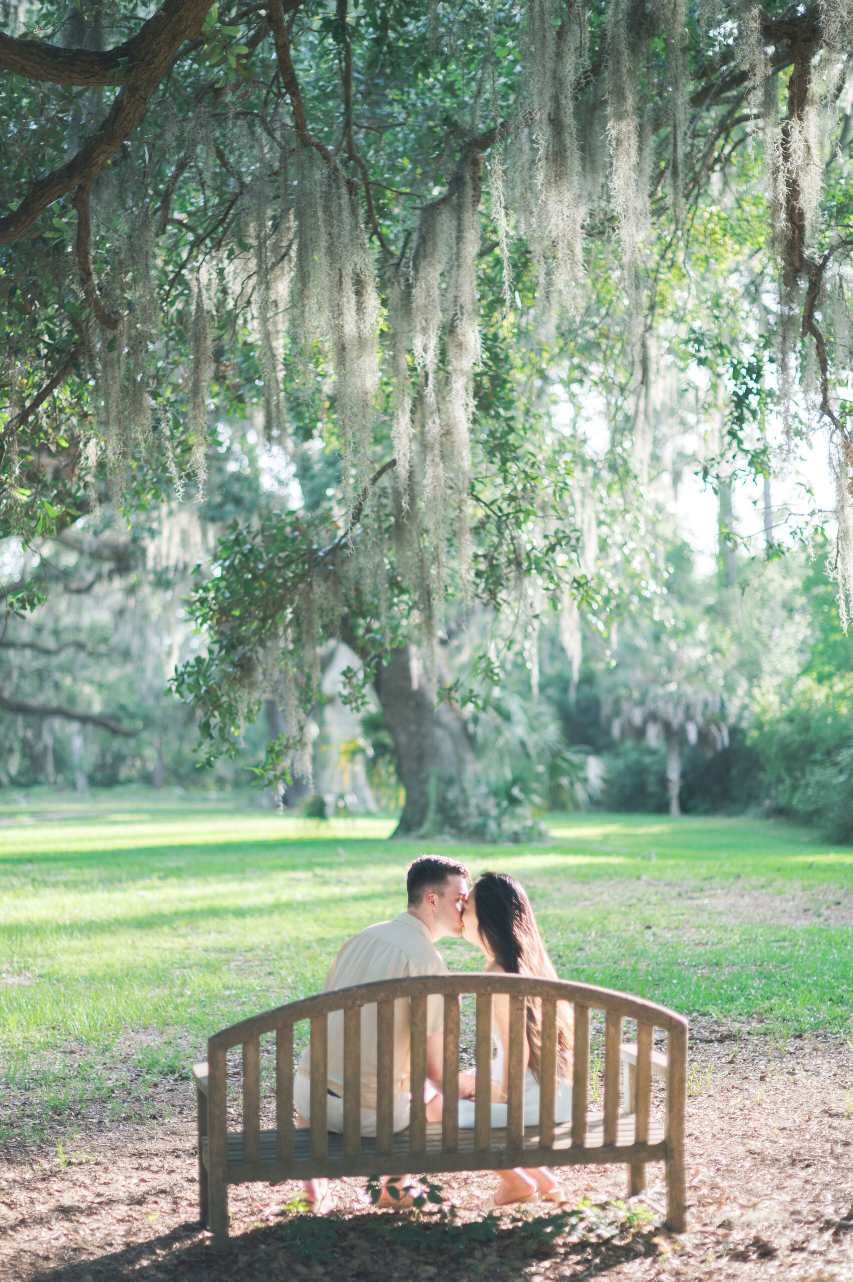 couple sitting on a bench at six oaks cemetery for their engagement portraits prior to their hilton head wedding